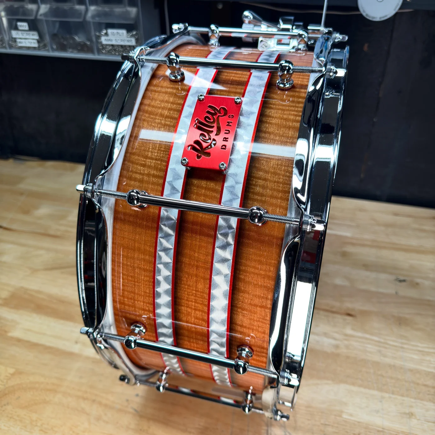A Kelley Drums wood snare with silver stripes, chrome hardware and a red Kelley badge
